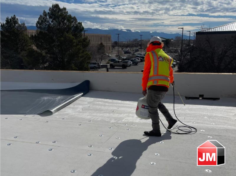 Professional roofers in Socorro, TX, installing a durable and weather-resistant TPO roofing system on a commercial building.