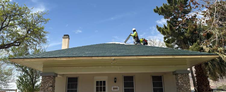 Professional JM Roofing contractor installing asphalt shingles on a residential home roof in El Paso, Texas, for an insurance claim replacement project.