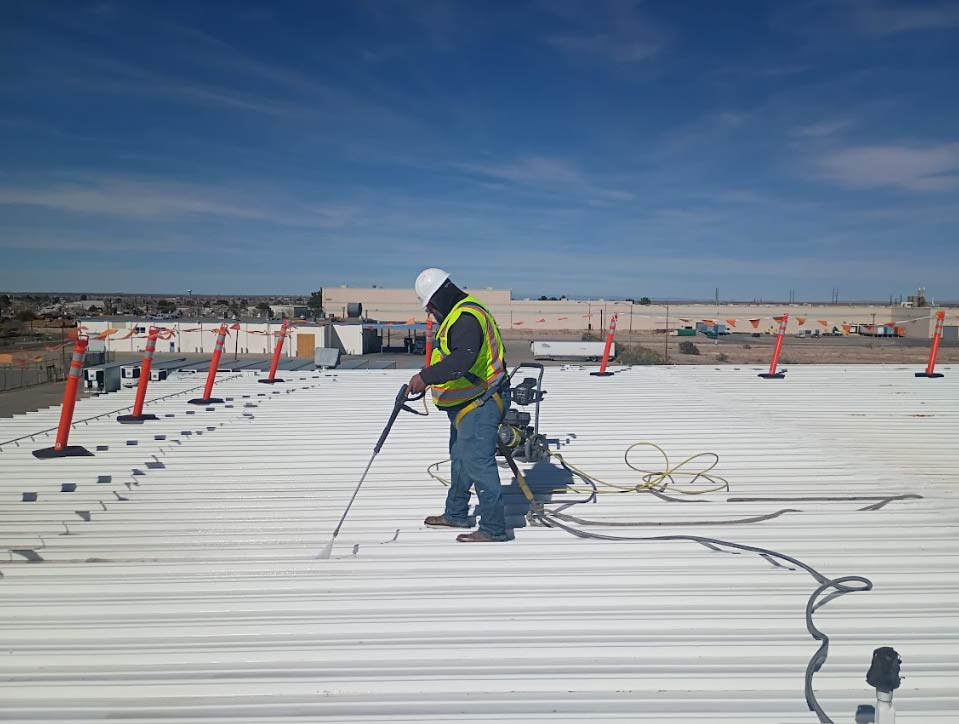 Close-up of durable elastomeric coating being applied to a metal roof surface for energy efficiency.
