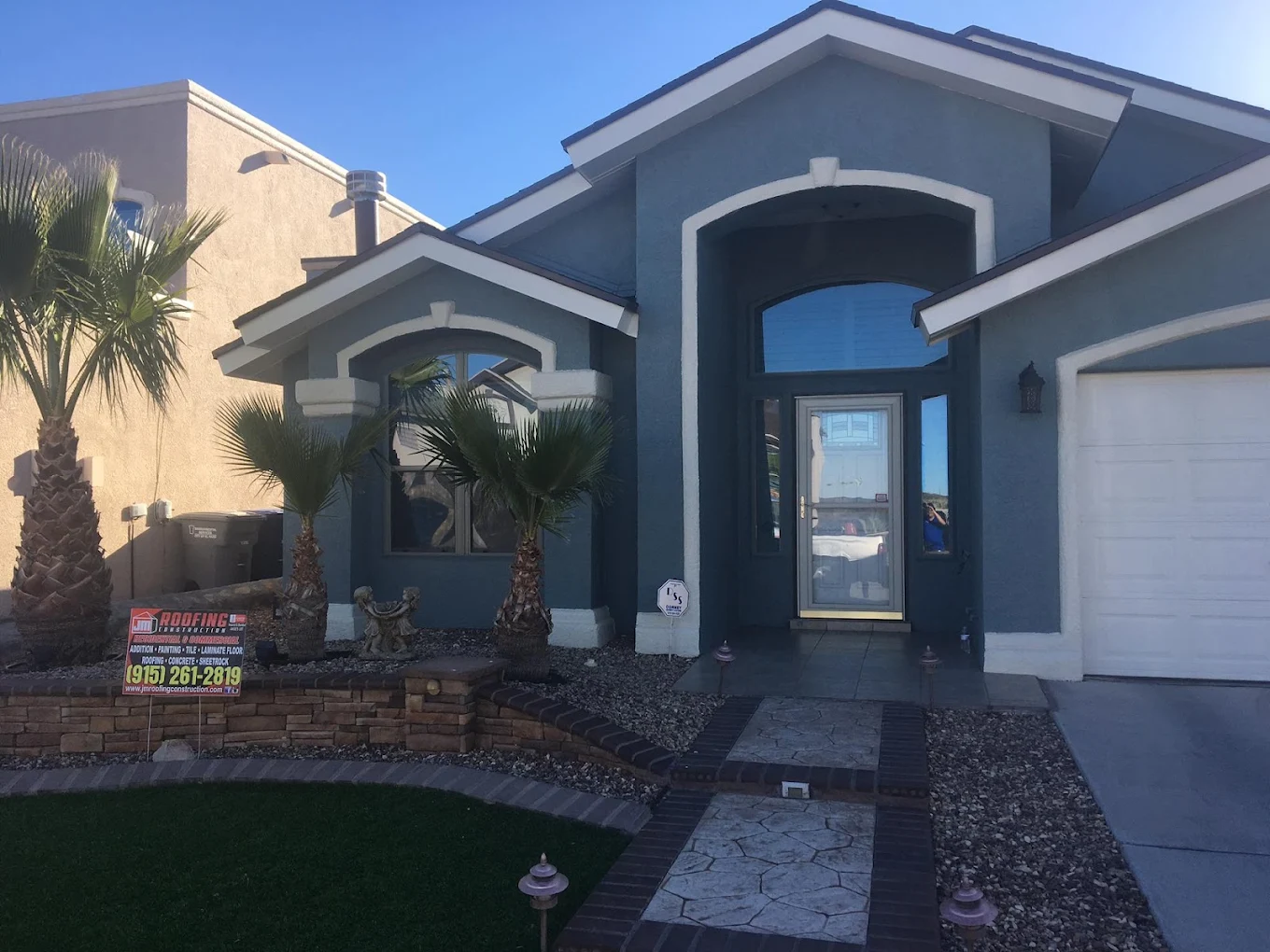 Freshly painted blue stucco home exterior with white trim in El Paso, TX
