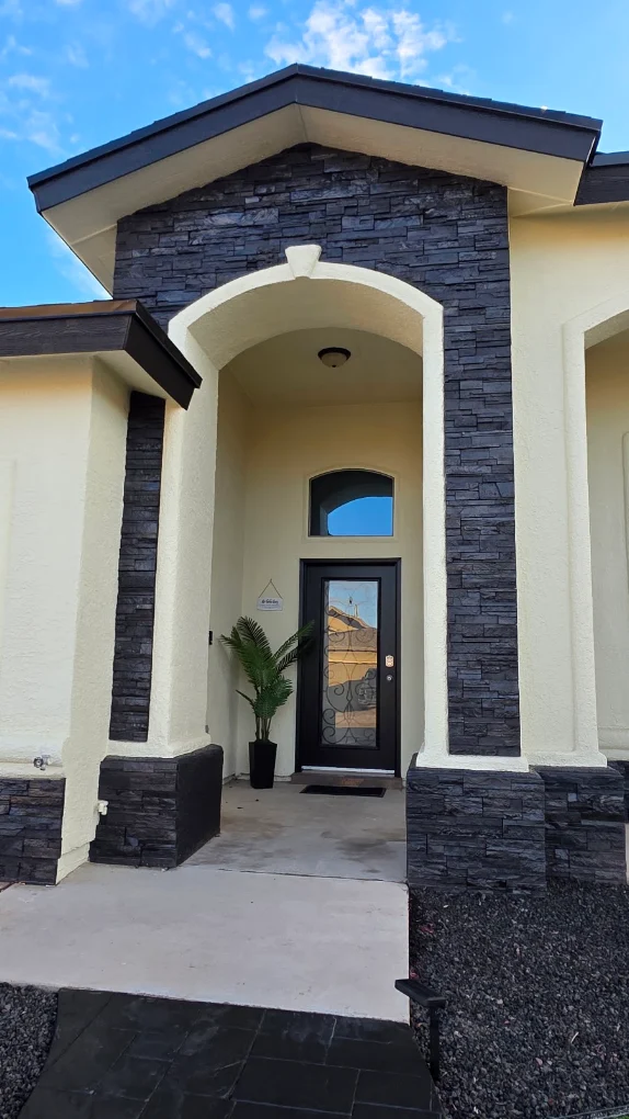 Close-up of stucco archway entrance with stacked stone trim after stucco installation